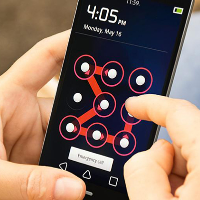 A pair of hands holding and swiping an unlock pattern on a mobile device